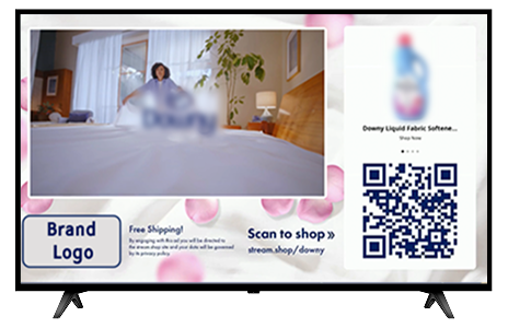 TV screen displaying a pink floral ad: a blurred person in a bedroom on the left, a brand logo box in the lower-left, and a QR code with 'Scan to shop' on the right.