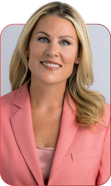 Professional head-and-shoulders portrait of a smiling blonde woman in a pink blazer.